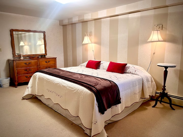 Dormitorio principal inferior con cama tamaño king nueva y baño privado.  ¡Dos armarios y mucho espacio en la cómoda en este enorme dormitorio!