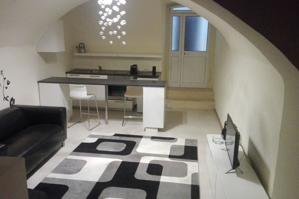 soggiorno superiore con tappeto infinito otto e cucina ad induzione total white