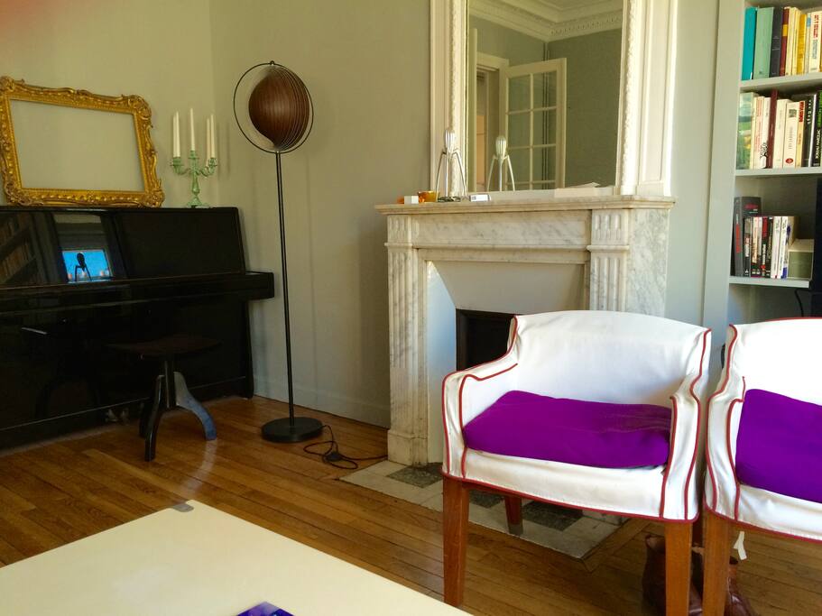 Salon avec piano et cheminée