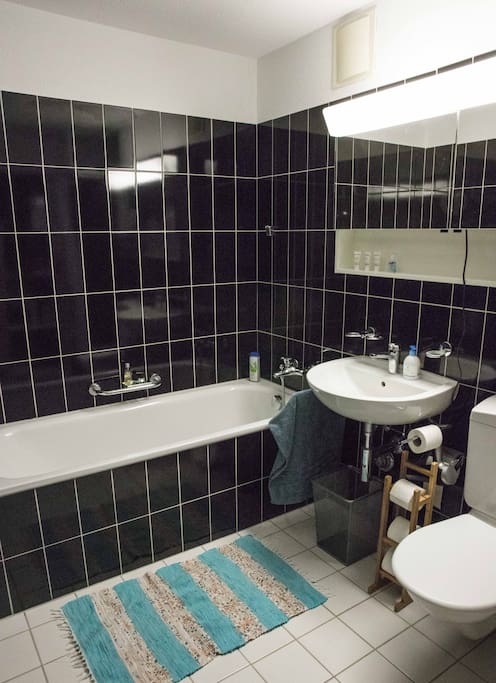 Bathroom with a hair dryer and a tub.