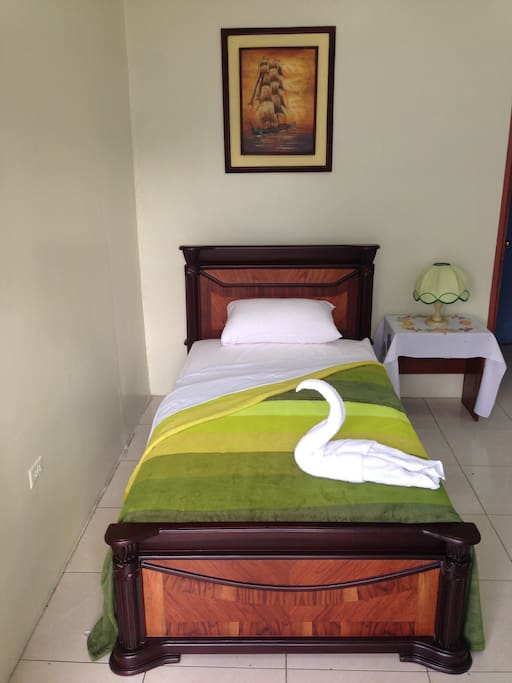 Cama individual en habitación privada con baño completo y aire acondicionado