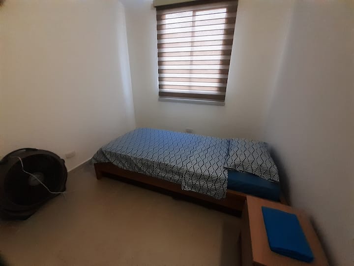 Druhá izba s jednolôžkom, vysokým šatníkom, nočným stolíkom a výhľadom na ulicu.