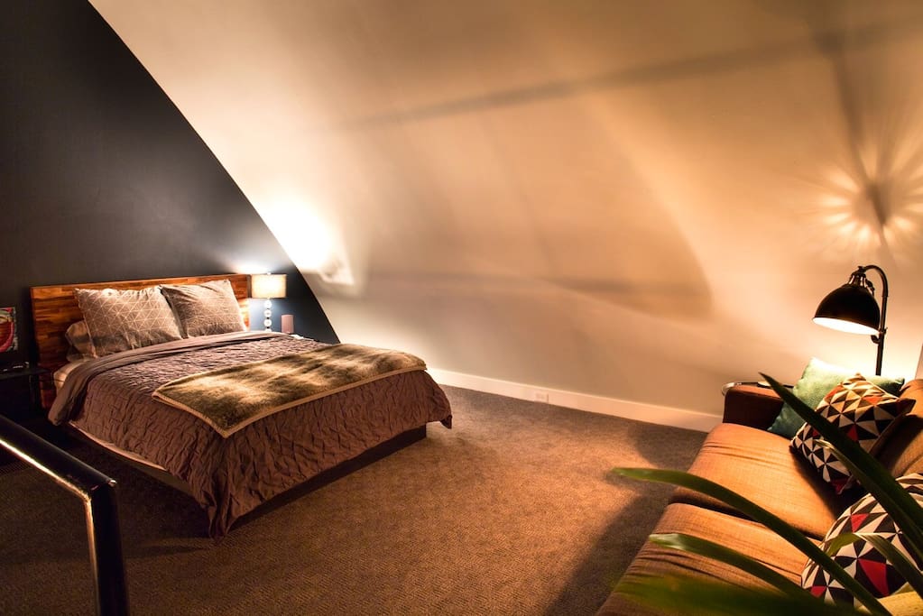 The upstairs loft bedroom is furnished with a comfy queen platform bed and pillow-top mattress.