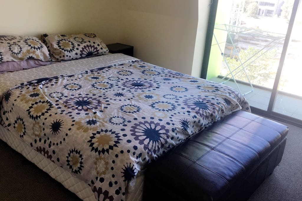 Large ensuite bedroom with balcony and queen size bed. Massive wardrobe and drawers with bed side lockers and lamps