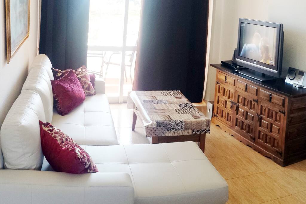 Salón con sofá cama cheslon y TV plana de 32".