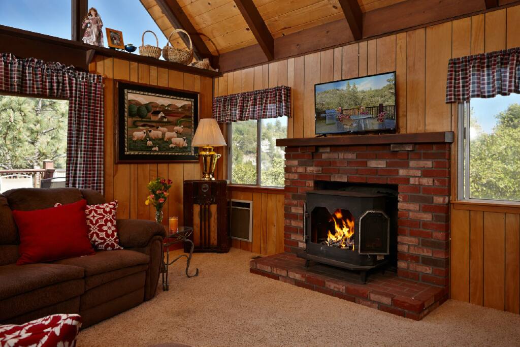Living room with TV and fireplace. Nice views from inside the home as well.