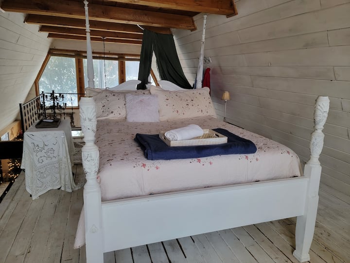 Upstairs  loft bedroom with clawfoot tub and amazing  window views