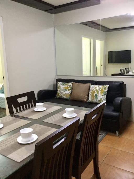 The dining area facing the living room with soft & comfly black sofa for your relaxing time :)