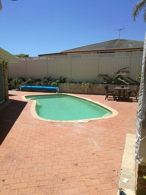 Sunny pool deck including large outdoor bbq and cantilever umbrella