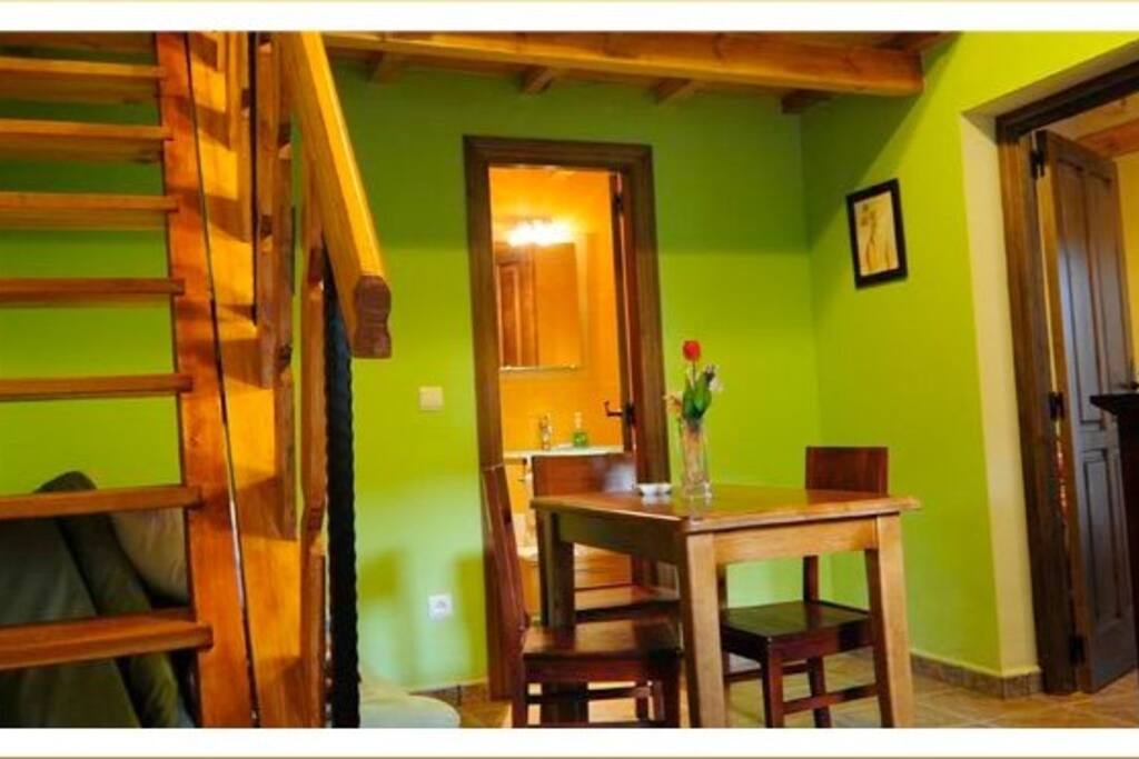 foto tomada desde la puerta de la cocina , escalera ahacia habitacion de arriba y a la derecha puerta a habitacion principal al lado de la chimenea , al fondo el baño