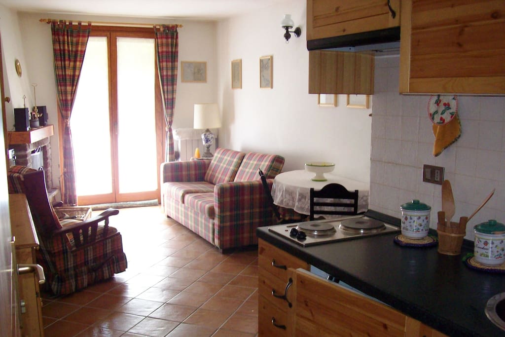 Soggiorno con cucina a vista con accesso su giardino privato