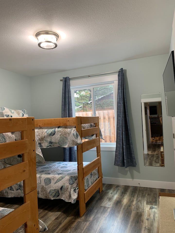 Third bedroom with 2 sets of solid wood bunk beds,  comfortable twin mattresses, a 43 in. smart TV with apps for streaming and a walk in closet.  A tri-fold twin sized portable mattress is stored in the closet.