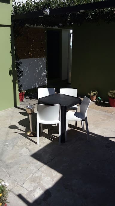 Patio equipado con mesa de jardin y cuatro sillas. excelente para tomar mates a la tarde.