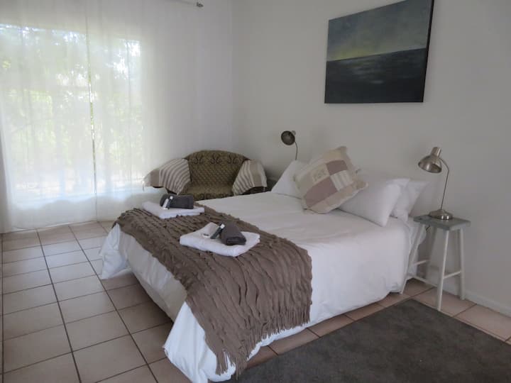 Spacious and tranquil main bedroom with view of garden. Ample storage space in cupboards. En suite bathroom.