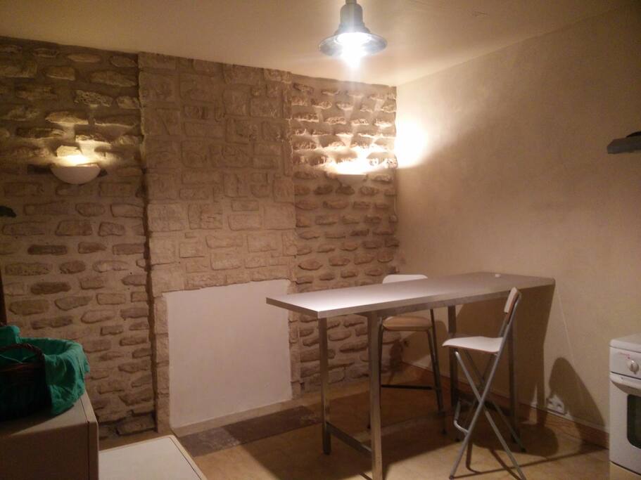 la cuisine salle à manger est spacieuse et agréable avec son mur en pierres apparentes