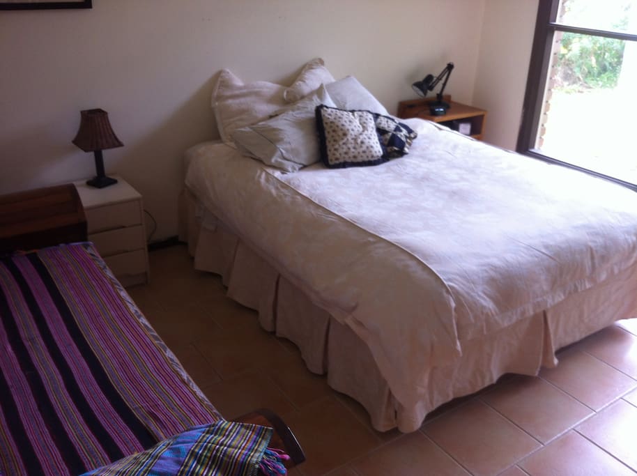 Queensize bed with large window onto garden