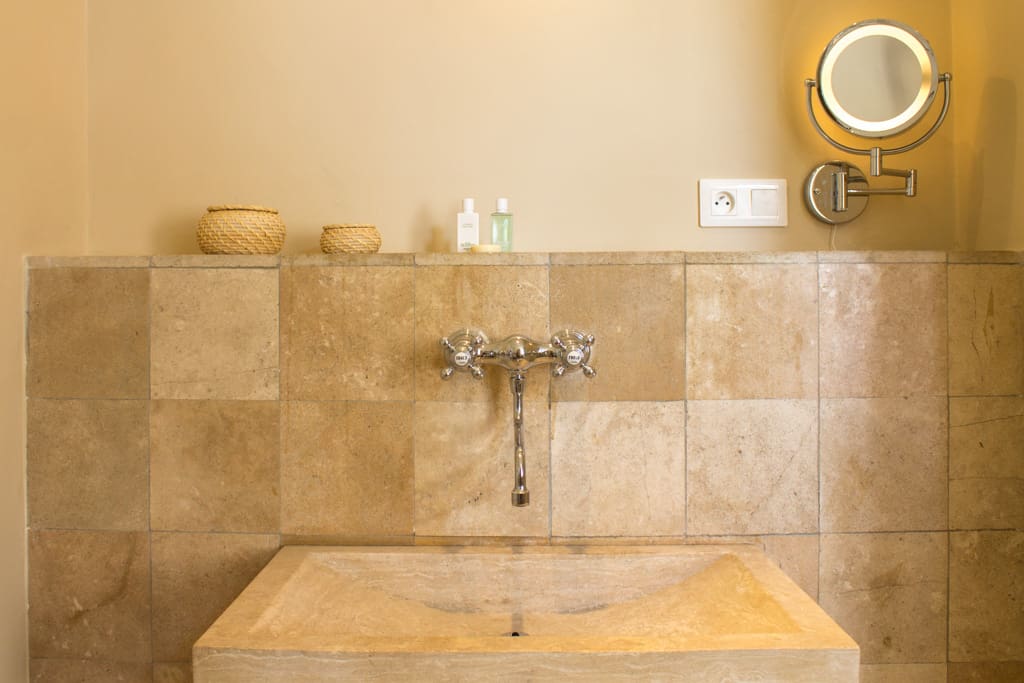 Marble tiled bathroom with heated towel rail, large shower, private WC, garden view