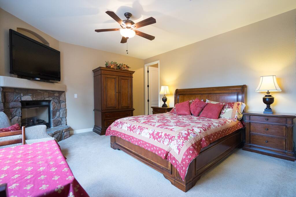 King bed, closet, table, TV and fireplace