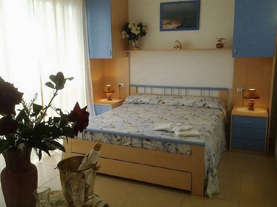 Spaziosa camera matrimoniale con terzo letto aggiunto, bagno privato, lungo balcone vista mare, aria condizionata, tv lcd, wifi