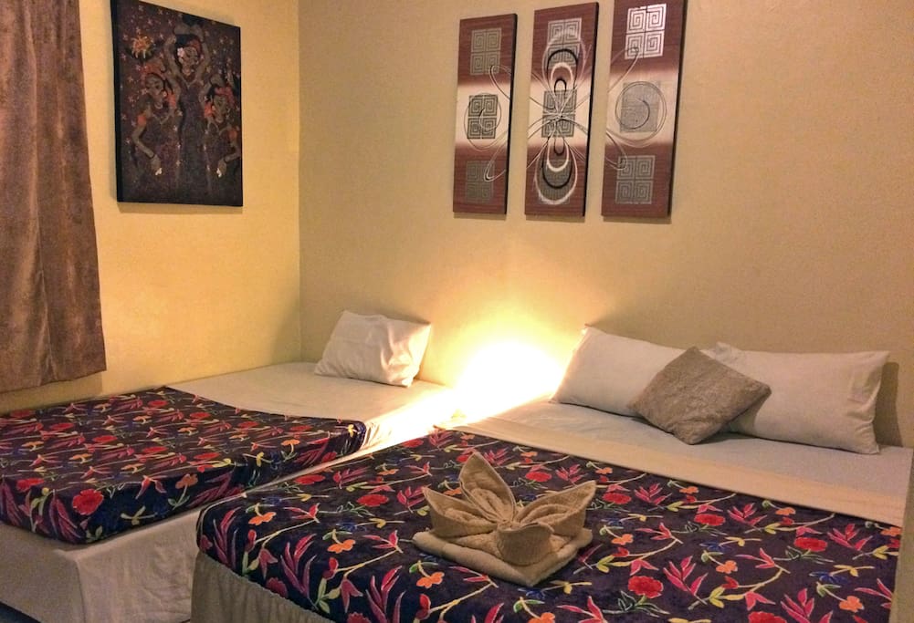 1 Queen Bed, 1 Single Bed, Large Window, Bedside Tables, Rattan Lamps. Local Balinese Artwork. Daily Cleaning is included. Toilet Paper and Soap are also included.