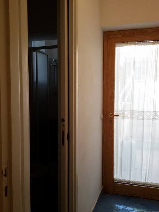 Porta di ingresso del bagno con a destra il portoncino