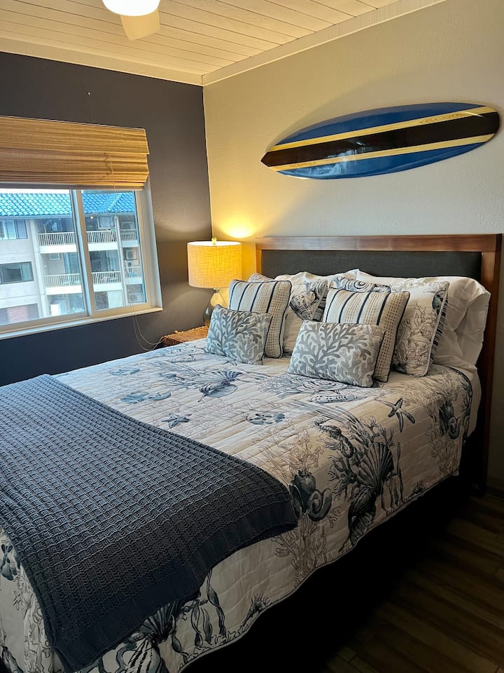 Cama tamaño queen del segundo dormitorio, televisión y ventilador de techo.