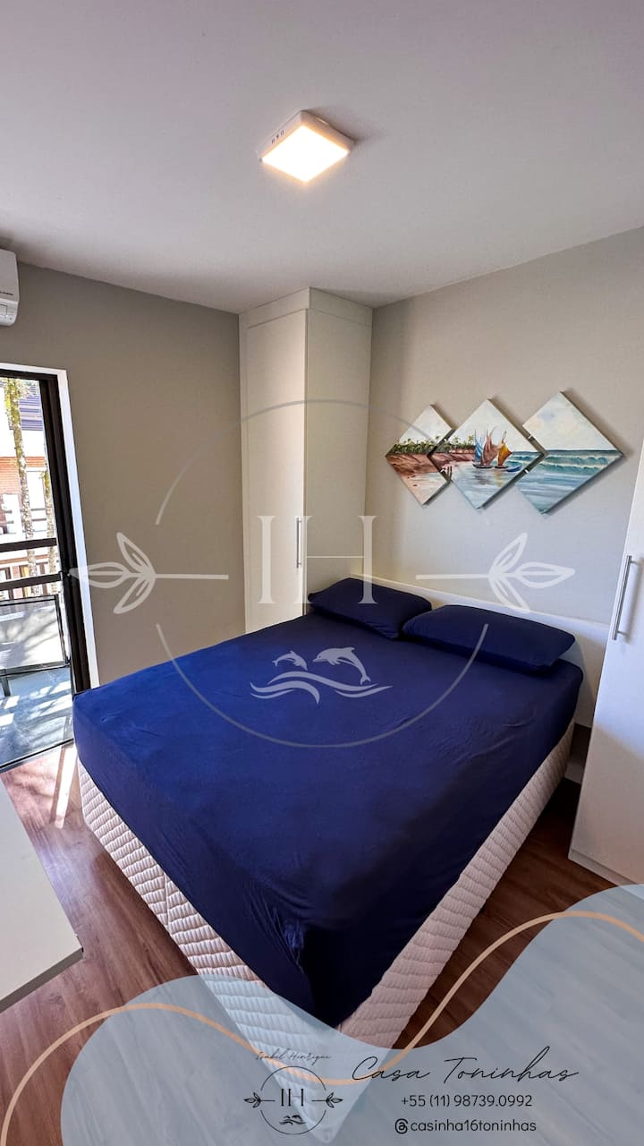 1张双人床（软床垫）、橱柜、桌子、空调和带椅子的阳台