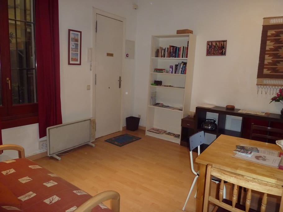 Salón amplio, con sofá-cama y mesa con sillas.