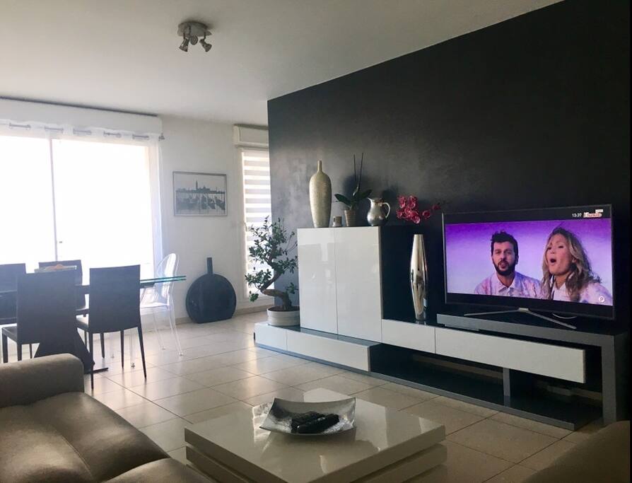 Pièce à vivre avec salon et salle à manger donnant sur la terrasse et la cuisine.