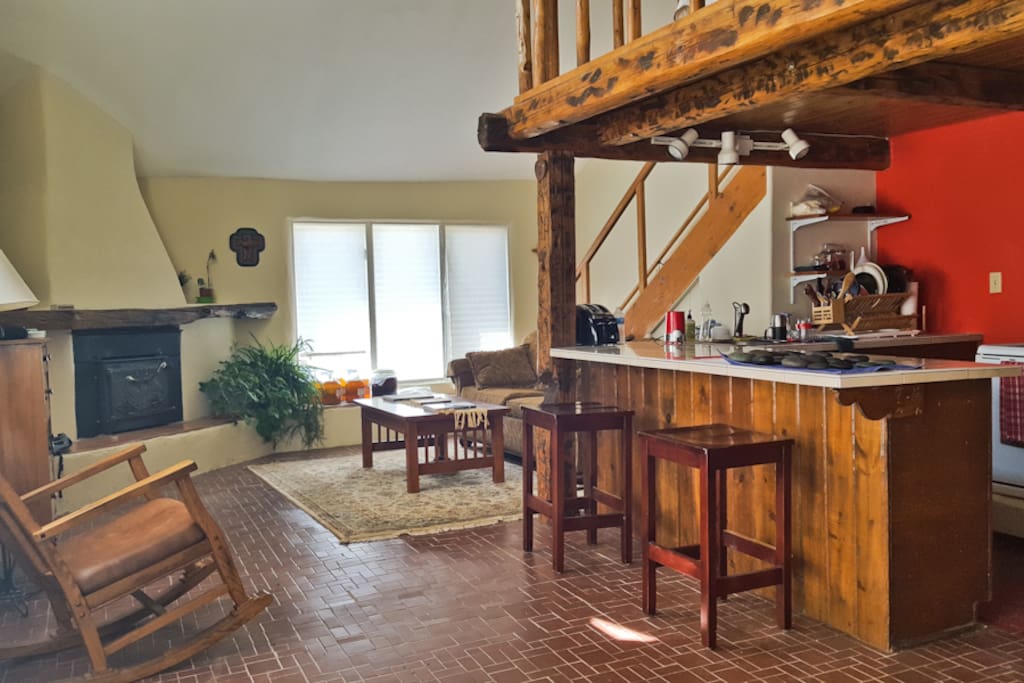 View of the fireplace and the kitchen bar