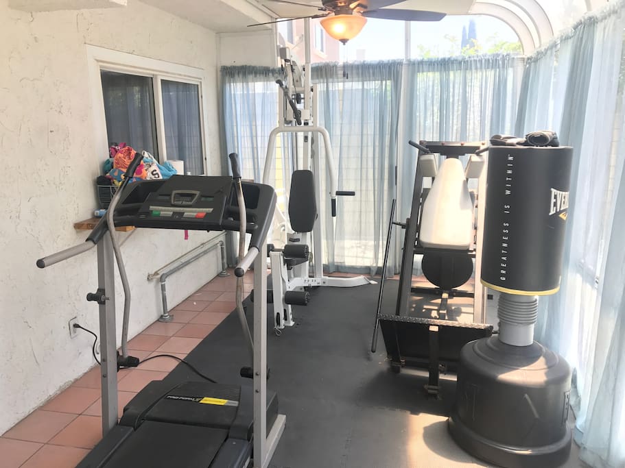 Gym with treadmill, weight machine, squat machine, and yoga equipment
