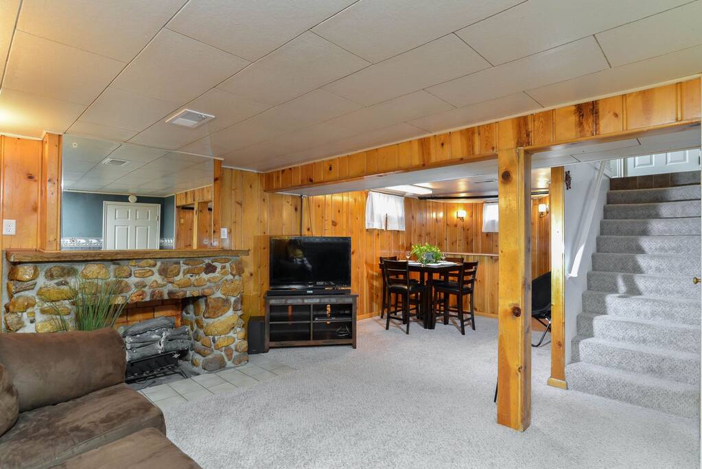 Basement family room with sectional, fireplace, TV, dining table