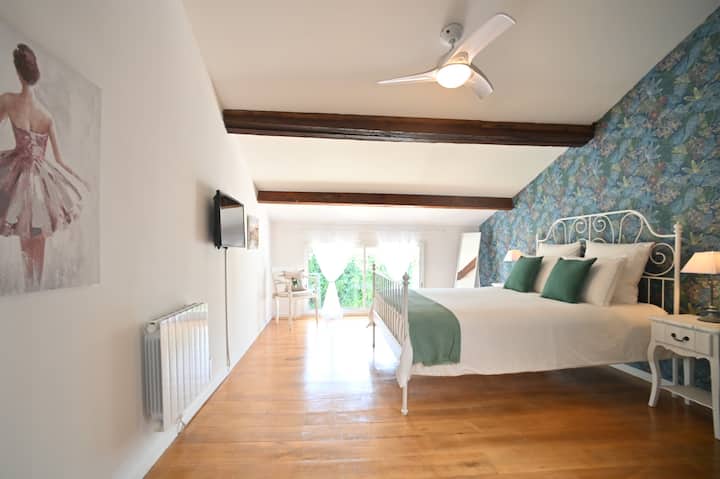 غرفة نوم رئيسية بإطلالة على الحديقة وتلفزيون