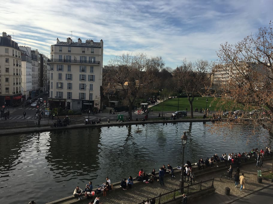 The view on the Canal St Martin. Enjoy the sun, the water, the park right in front