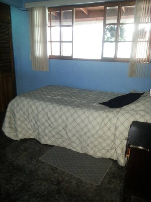 Dormitorio de huéspedes, tiene luz natural cuando se abren las persianas. consta de closet para la ropa, escritorio con su silla, cama y veladora.