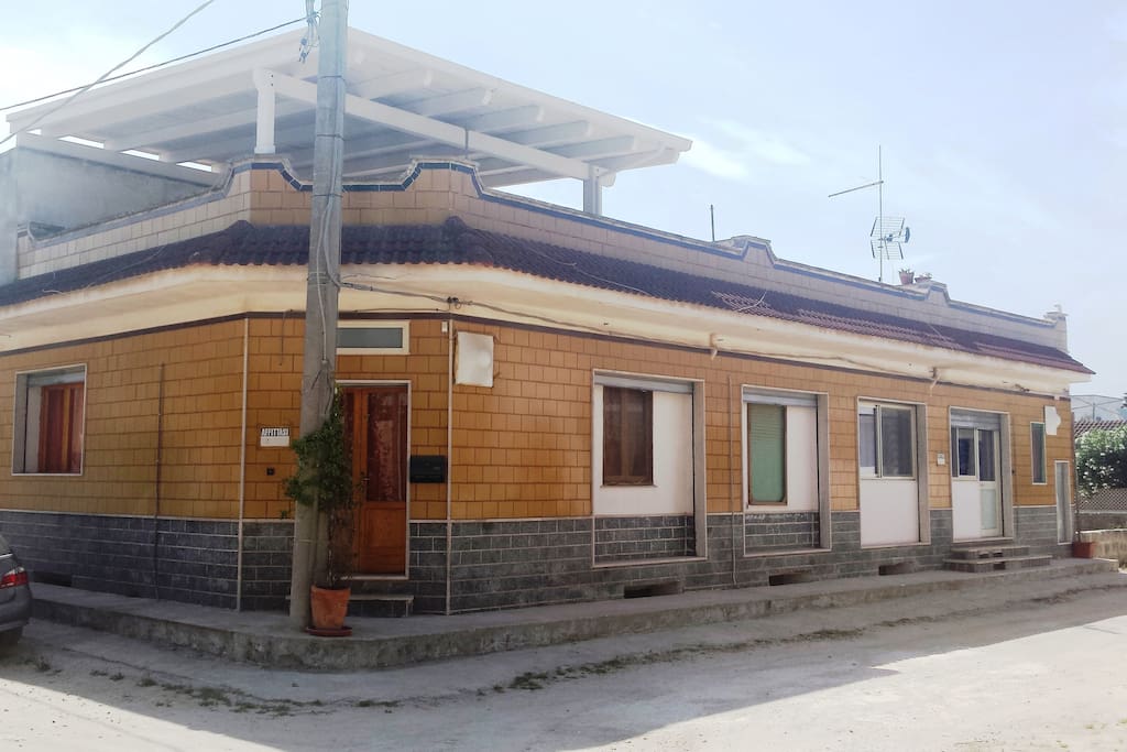 Esterno casa, con ingresso ad angolo e terrazza in parte coperta