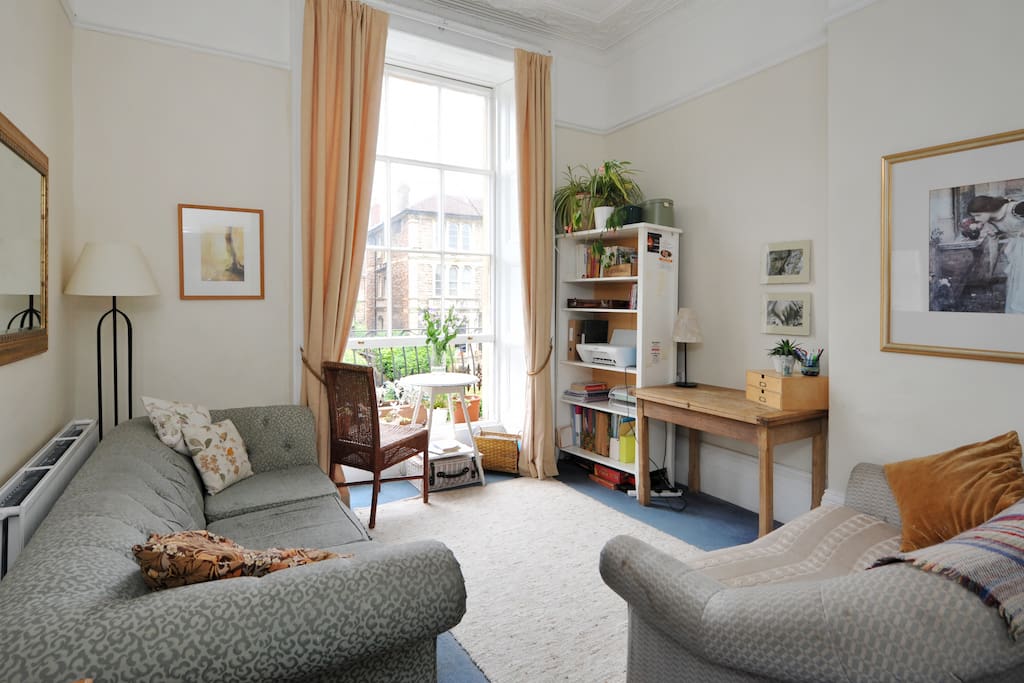 Sunny lounge with floor to ceiling sash window.
