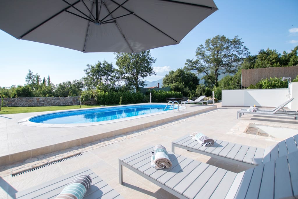 Beautiful swimming pool area, fully equipped with sunbeds, parasols and showers. Pool is surrounded with lawn.