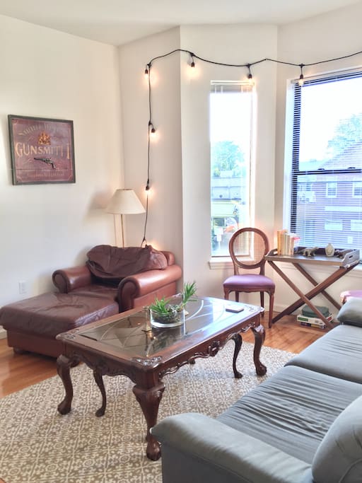 Charming, sunny living room with bay window. The living room sofa is super comfortable, and the lighting and local art (from Nantucket) make it a great room to hang out in.