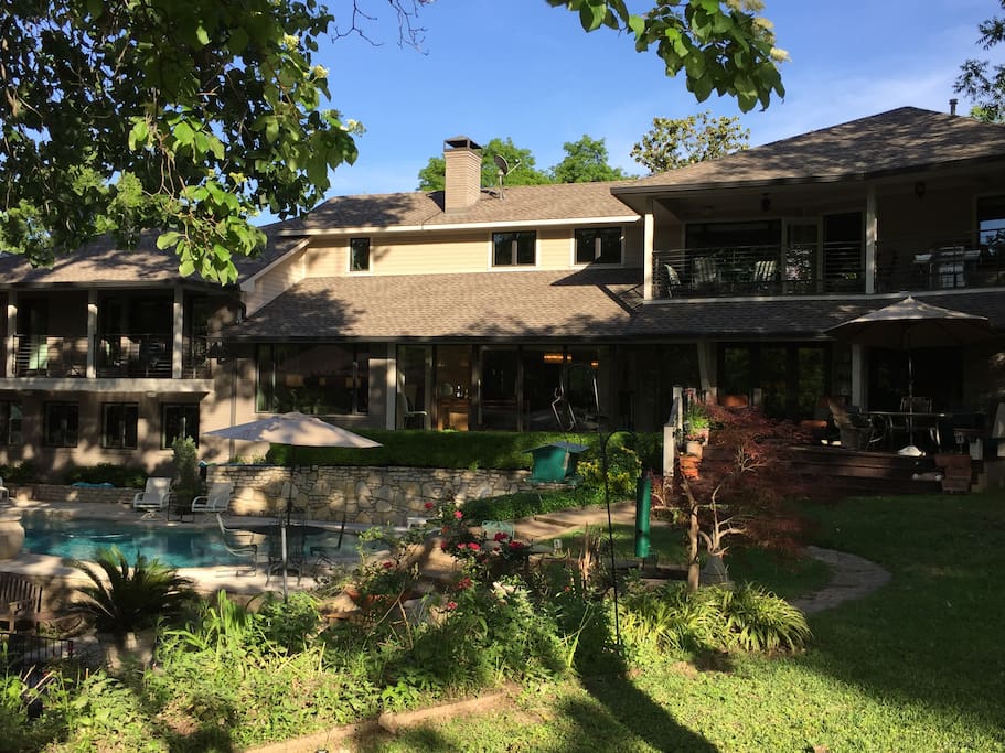 Backyard shot of the home, pool, and multiple deck spaces.