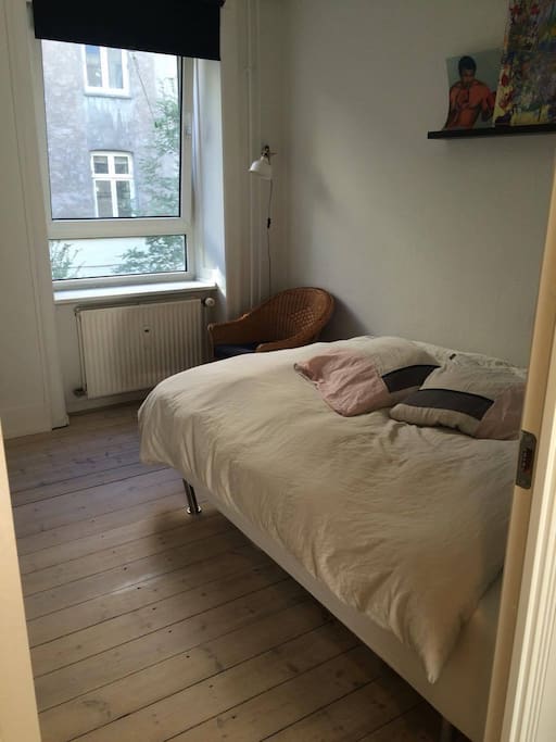 bedroom with a double bed and a big window with blackout curtain. The bedroom is out to a quiet courtyard so you wont hear the noise from the streets
