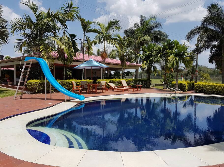 Piscina privada con resbaladero y sillas de bronceo