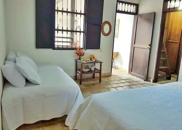 Alcoba # 2,   with window overlooking the courtyard. A spacious bathroom and dresser.