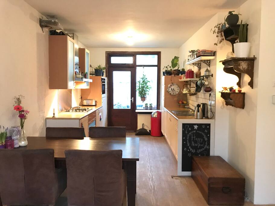 Eettafel met open keuken, en deur naar de achtertuin.