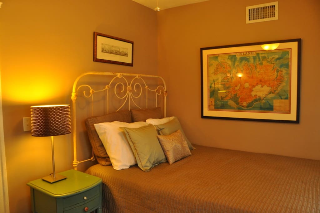 Queen-sized antique wrought iron bed in guest bedroom.