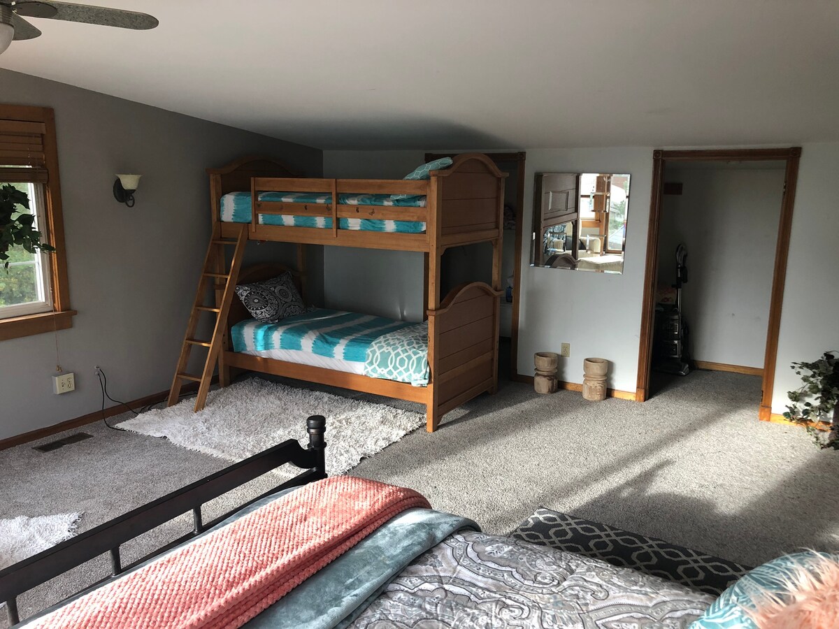 Dormitorio principal con cama tamaño queen y literas individuales.