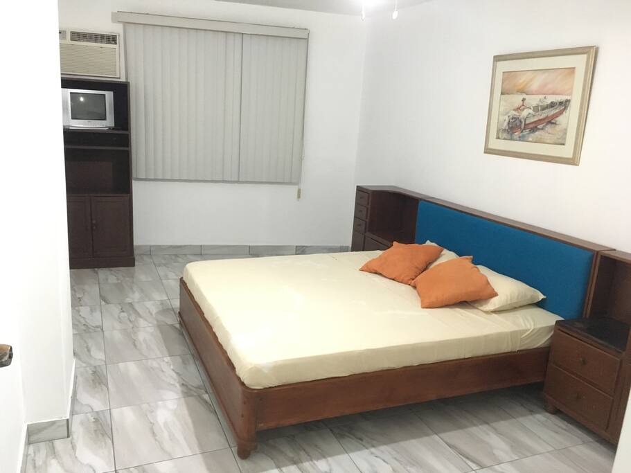 Dormitorio con TV, aire acondicionado y entrada directa al baño.