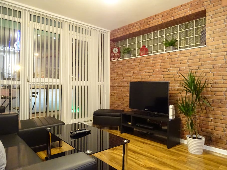 Modern living area with sofa & seating, TV & coffee table.