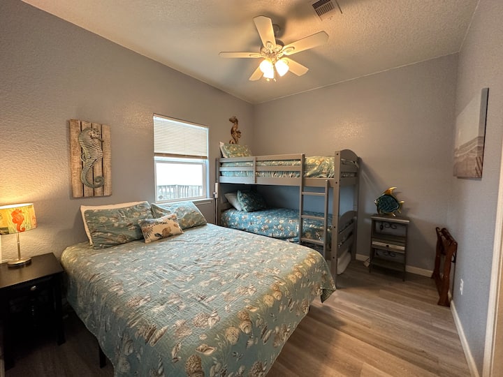 Primary bedroom with a queen size bed and two twins