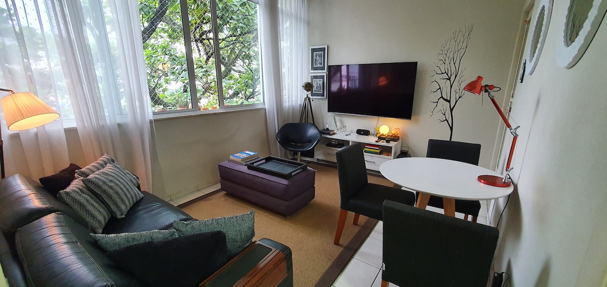 Sebule kubwa iliyo na TV ya inchi 75, sofa, meza, viti na Puff.